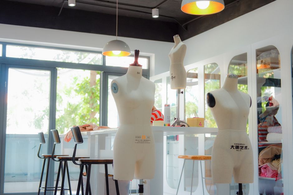 Bright contemporary tailoring workshop with mannequins and sewing accessories.