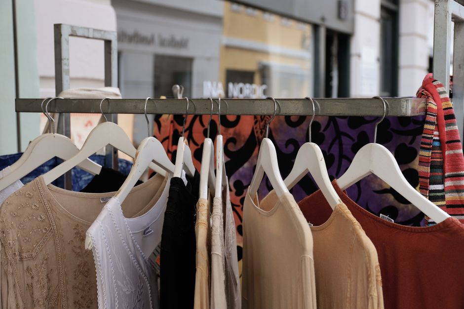 Vibrant clothing on hangers at a boutique in Copenhagen, capturing diverse textures and patterns.